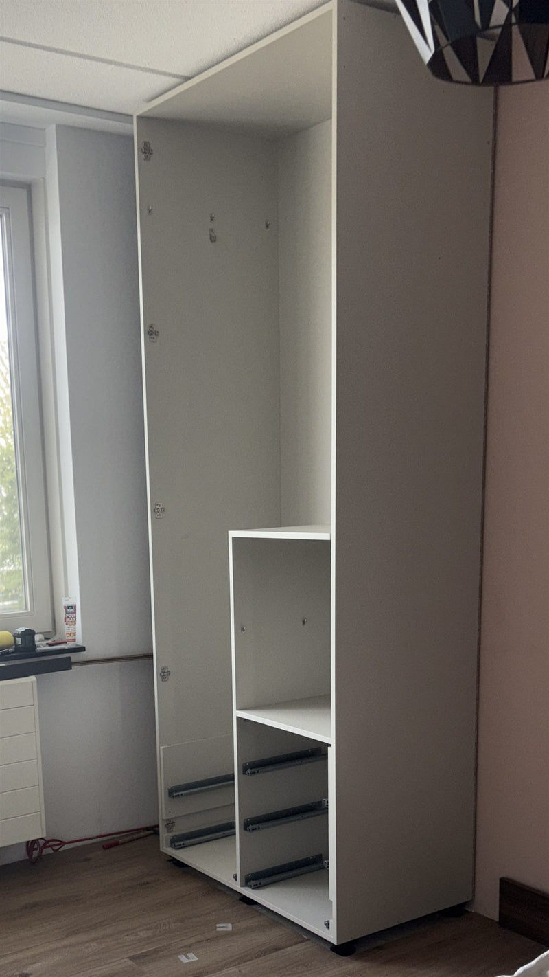 De lichte binnenkast tijdens de montage, ingehuisd tussen de zijpanelen.